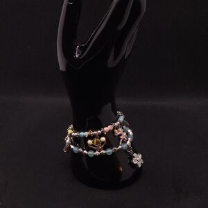 Colourful beaded bracelet with charms, featuring a mix of silver, blue, pink,